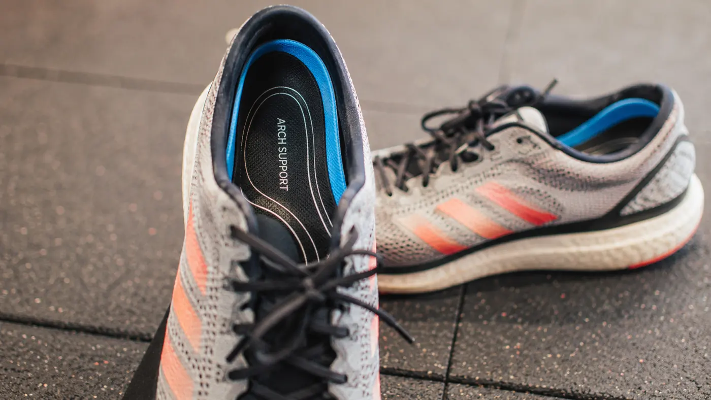 Arch support insoles placed inside a running shoe, ready to lace up for a morning run