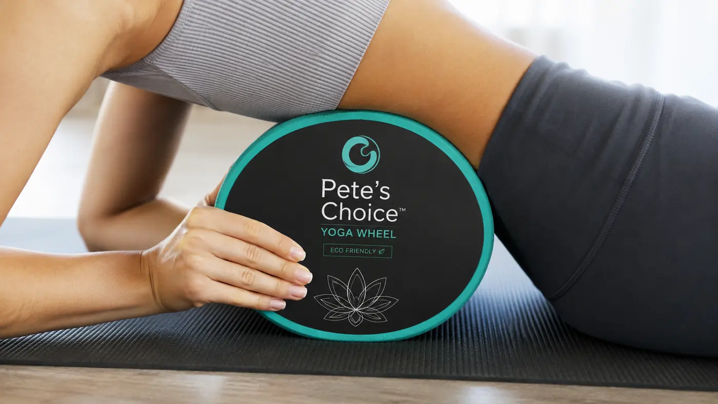 Hands positioning a yoga wheel behind the upper back before a thoracic rolling session